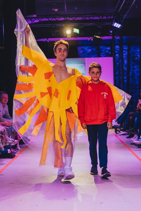 Kind und sein Mode-Entwurf gehen über die Bühne