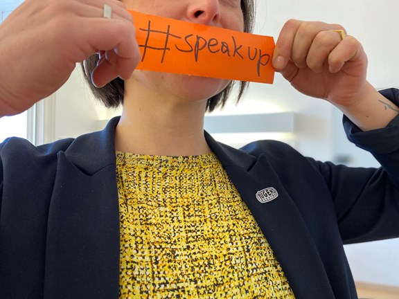Person mit Hashtag-Plakat: Speakup